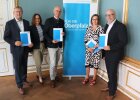 Regierungspräsident Walter Jonas zeigt zusammen mit Ludwig Friedl von der Energieagentur Regensburg, Bereichsleiterin Christiane Zürn, Sigrun Denner von der Geschäftsstelle Energiewende an der Regierung der Oberpfalz und Matthias Rösch vom etz Nordoberpfalz die unterzeichneten Verträge zum Energiecoaching