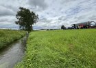 Bach, Wiese und landwirtschaftliches Gerät mit den Teilnehmern des Wasserpakts