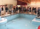 Exkursionsteilnehmer vor einem leeren Becken des ehemaligen Badehaus Maiersreuth.