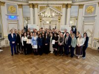 Gruppenfoto im festlich geschmückten Spiegelsaal der Regierung der Oberpfalz. Rund 30 Personen – darunter die Preisträgerinnen und Preisträger des Integrationspreises 2025, Ehrengäste sowie Vertreterinnen und Vertreter der Regierung der Oberpfalz – stehen zusammen, einige halten Urkunden in den Händen. Im Hintergrund sind Banner mit der Aufschrift „Integration leben – In Bayern daheim“ zu sehen.