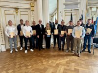 Gruppenfoto mit Regierungspräsident Walter Jonas und den elf Geehrten der Lebensretter-Ehrung in der Regierung der Oberpfalz, alle halten ihre Urkunden in den Händen.
