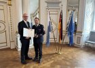 Regierungspräsident Walter Jonas händigt Kreisbrandinspektor Michael Iberer (Landkreis Amberg-Sulzbach) das Steckkreuz für besondere Verdienste um das Feuerwehrwesen aus.
