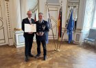 Regierungspräsident Walter Jonas händigt Oberbrandmeister Hermann Schreyer (Wernberg-Köblitz, Landkreis Schwandorf) das Steckkreuz für besondere Verdienste um das Feuerwehrwesen aus.