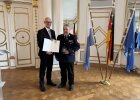 Regierungspräsident Walter Jonas händigt Kreisbrandmeister Christian Stöckel (Landkreis Regensburg) das Steckkreuz für besondere Verdienste um das Feuerwehrwesen aus.