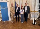 Eine Schülerin der Mädchenrealschule Waldsassen präsentiert ihre Urkunde gemeinsam mit Ehrengästen.