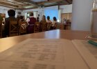 Hubert Fischer spricht vor den Gästen, im Vordergrund liegen Veranstaltungsunterlagen auf einem Tisch.