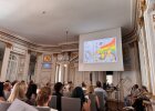 Auf einer Leinwand im Spiegelsaal wird ein Siegerreel des Kreativwettbewerbs gezeigt.